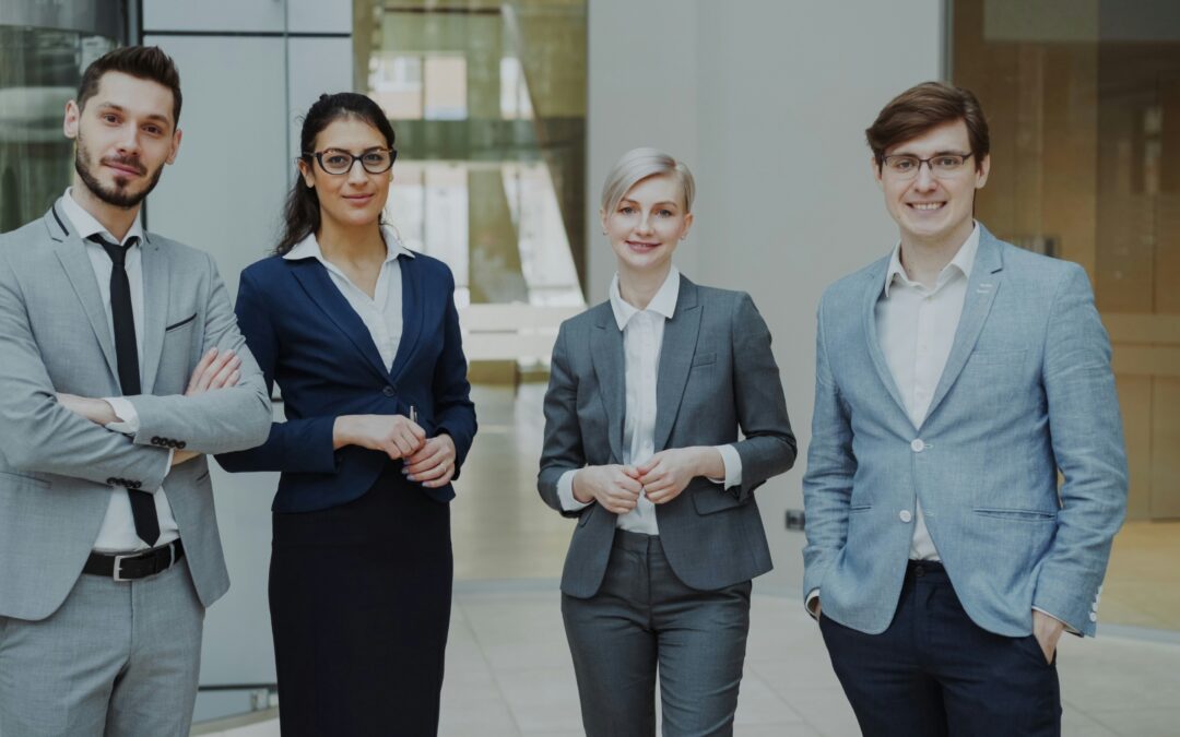 vier Profis in Businesskleidung stehen zusammen
