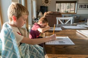 Homeschooling zwei Kinder am Schreibtisch